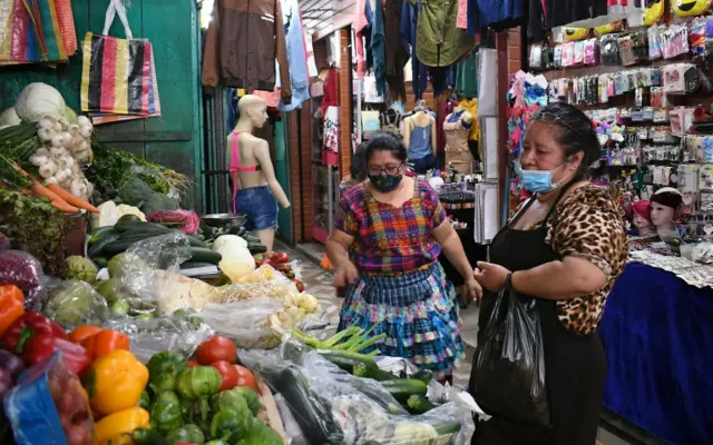 Women wear face masks as a preventive measure against the spread of the COVID-19 coronavirus at a market in Amatitlan, 35 km south of Guatemala City