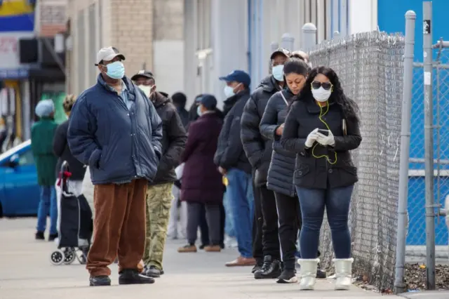 People queue for a money transfer service in New York