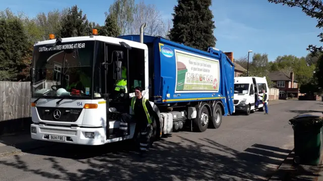 Bin lorry with minibus behind