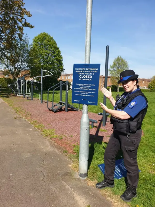 Police officer by a sign