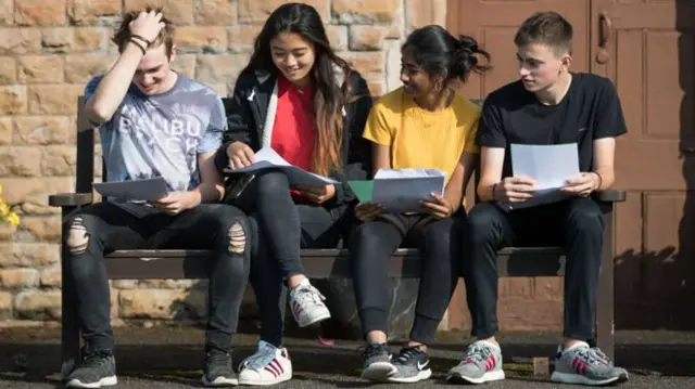 Young people reading their exam results