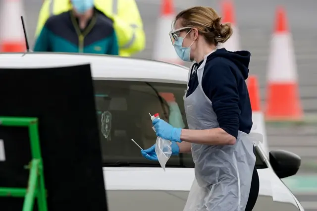 A nurse takes a swab at a Covid-19 Drive-Through testing station at Manchester Airport