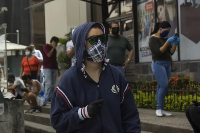 A man in Guayaquil, Ecuador walks through the streets wearing a mask