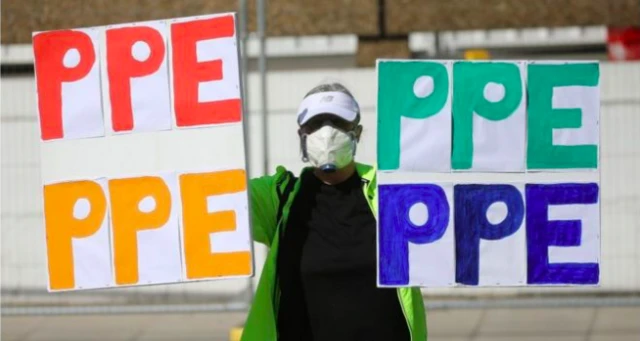 Man with PPE signs