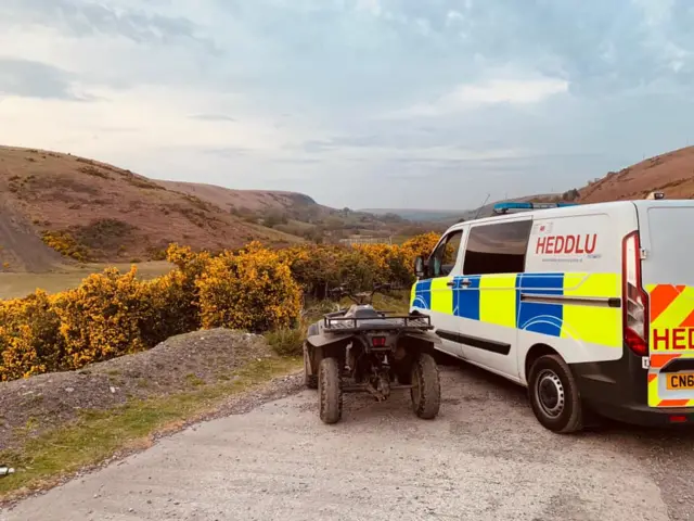 A quad bike next to a police van