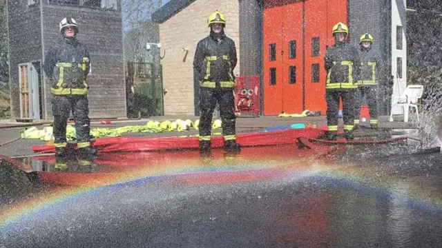 Firefighters and a rainbow