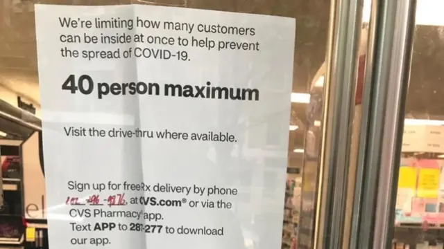 A sign outside a pharmacy says they are limiting the number of customers inside to 40 people