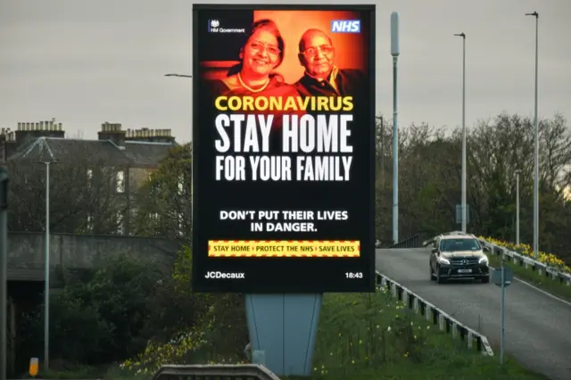 A coronavirus poster saying 'Stay Home for Your Family' over the western bypass in Edinburgh