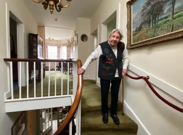 Margaret Payne on the stairs of her home in Ardvar, Sutherland