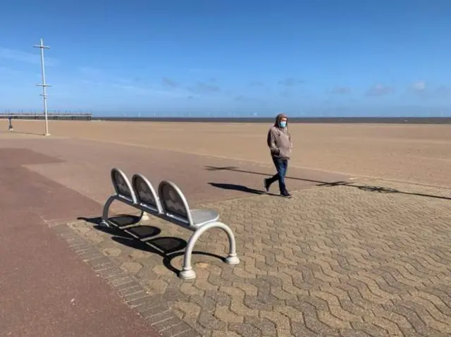 Man walking on beach in Skegness