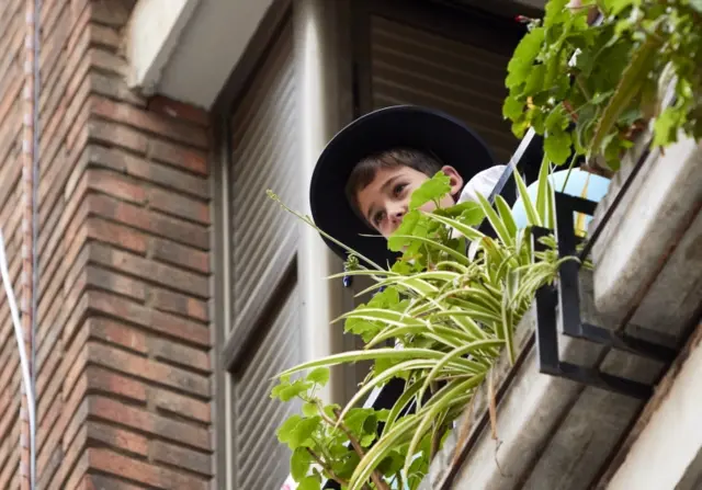 A child looks outside from a balcony