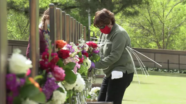 Museum staff are seen placing fresh flowers on each memorial chair