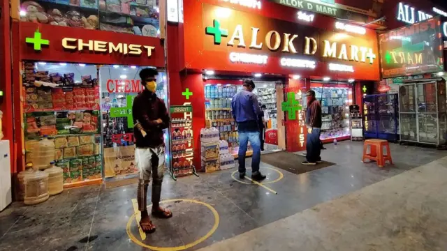 Pharmacy in New Delhi, India, with social distancing markers for people in the queue