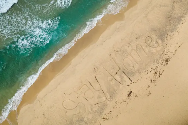 An aerial view of Bronte Beach with the words #StayHome written into the sand by local lifeguards