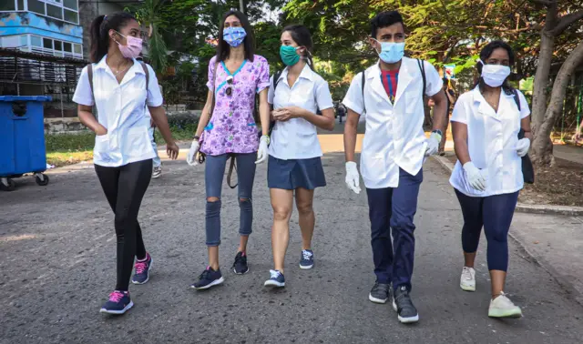 Medical students leave El Vedado polyclinic in Havana to go door by door looking for possible cases of the novel coronavirus, COVID-19, on March 31, 2020.