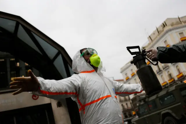 Health worker in Spain being disinfected