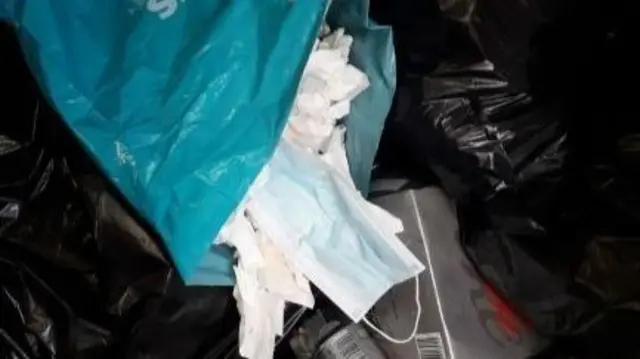 Face masks spilling out of bin bag