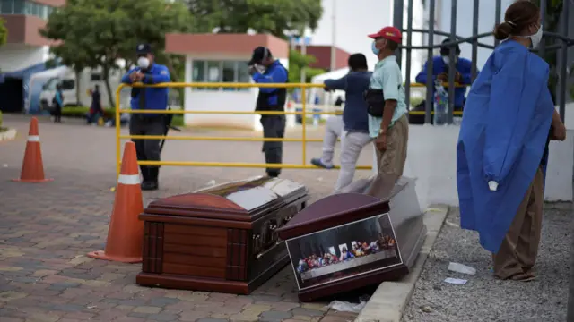 People wait next to coffins outside of Guasmo Sur General Hospital after Ecuador reported new cases of coronavirus disease (COVID-19), in Guayaquil, Ecuador April 1, 2020.