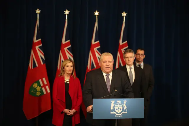 Premier Doug Ford holds a press conference flanked by cabinet members on 19 March