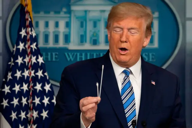 US President Donald Trump holds up a swab as he speaks during a Coronavirus Task Force press briefing