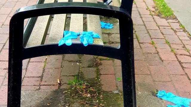 Disposable gloves on the floor and on a bench on Melton Road, Leicester