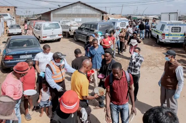 People queue as they wait for a food distribution near Johannesburg