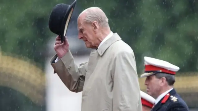 Prince Philip removes his hat during his last solo public engagement