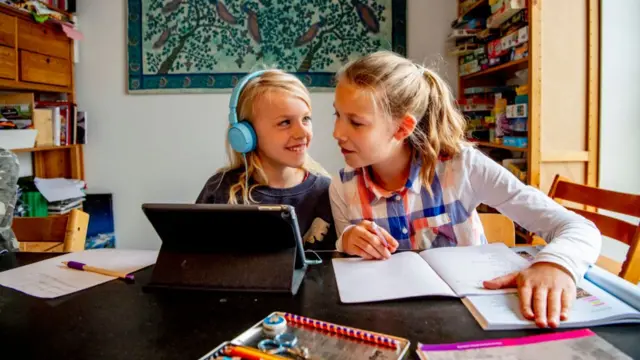 Two Dutch children doing school work at home during the lockdown