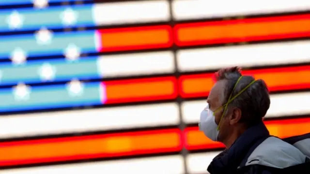 Man with face mask in front of US flag