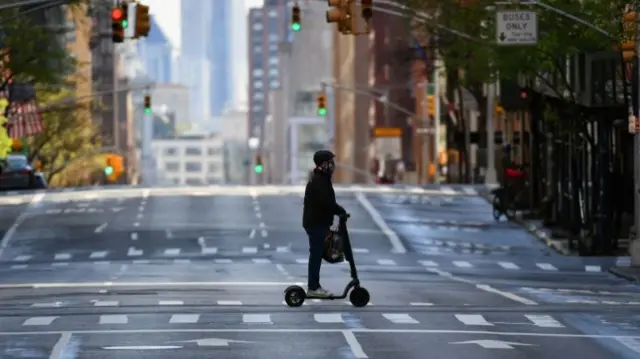 A person on a scooter in an empty New York street