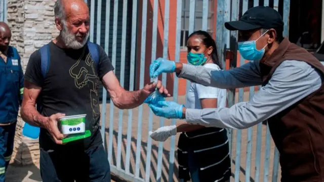 Volunteers distribute hot meals and sanitiser in Cleveland, near Johannesburg, on April 20, 2020.