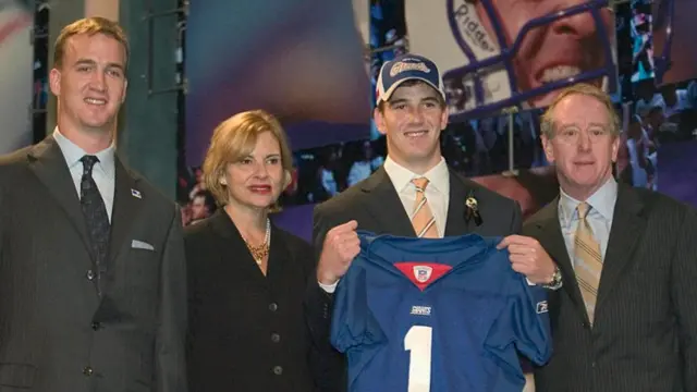 The Manning family with Eli holding a New York Giants jersey after being traded at the 2004 draft