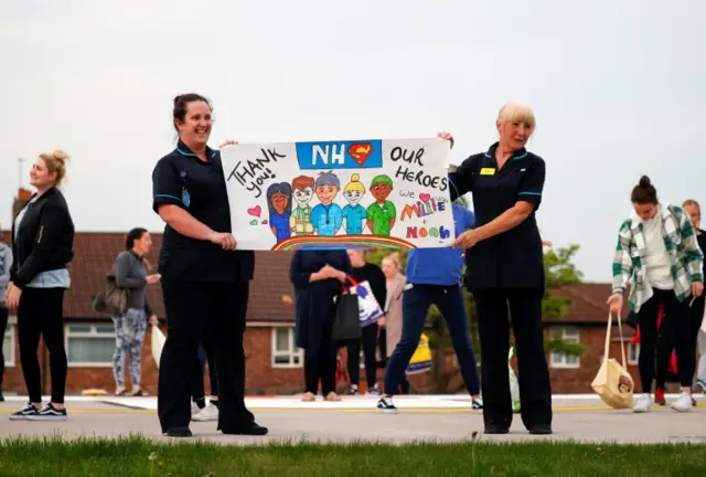 NHS workers hold a placard outside the Aintree University Hospital