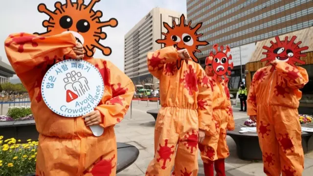 People dressed as virus urging to socially distance