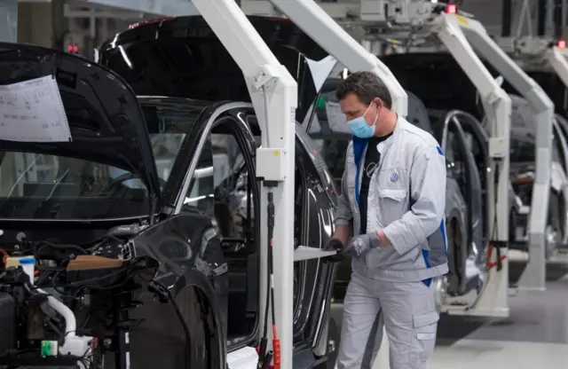 A worker at the VW plant in Zwickau inspects a car