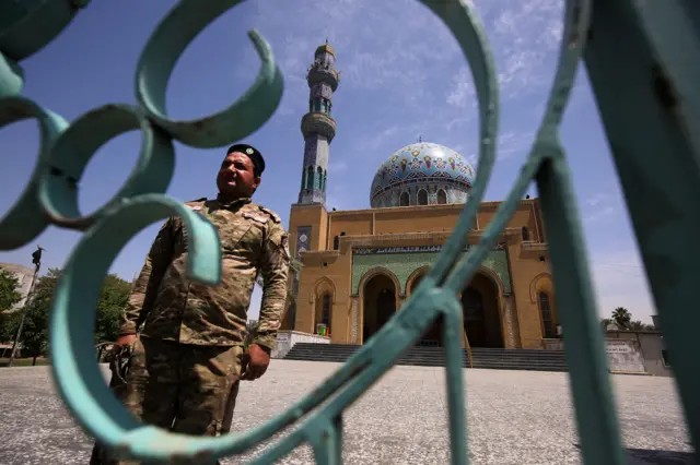 An Iraqi soldier stands in front of a shuttered mosque in Baghdad