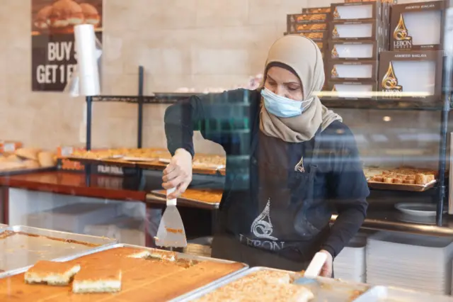 Employee of Lebon Sweets, Dona Awada, prepares sweets in between serving customers on the first day of Ramadan on April 23, 2020 in Dearborn Heights, Michigan.