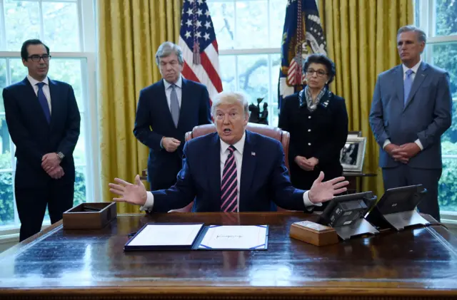 Donald Trump signs coronavirus aid package in the White House on 24 April