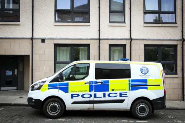 A police van outside a block of flats in Kelso