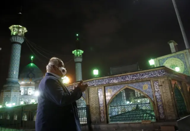 An Iranian man prays outside a mosque