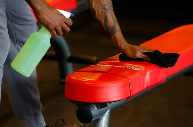 Disinfecting a work bench in a gym