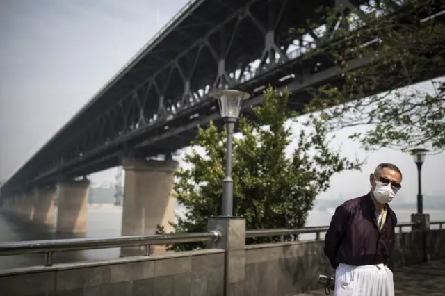 A man wears a mask while walking through Wuhan