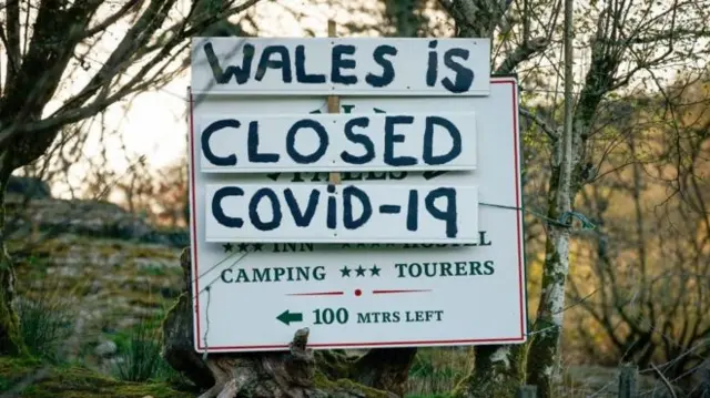 A sign reads "Wales is closed, covid-19"