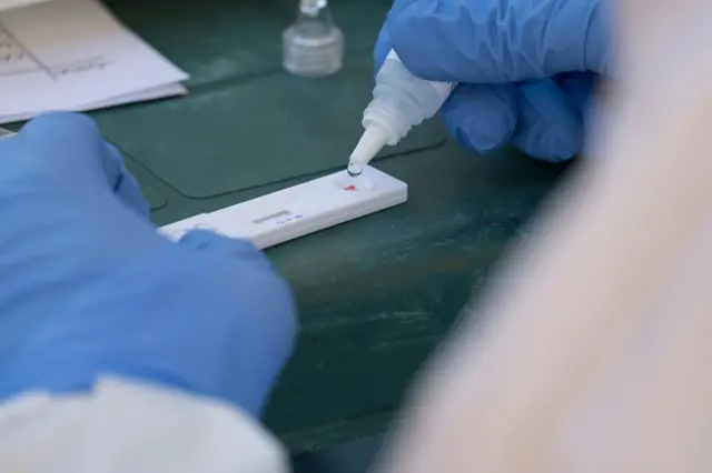 Health workers performing an antibody test