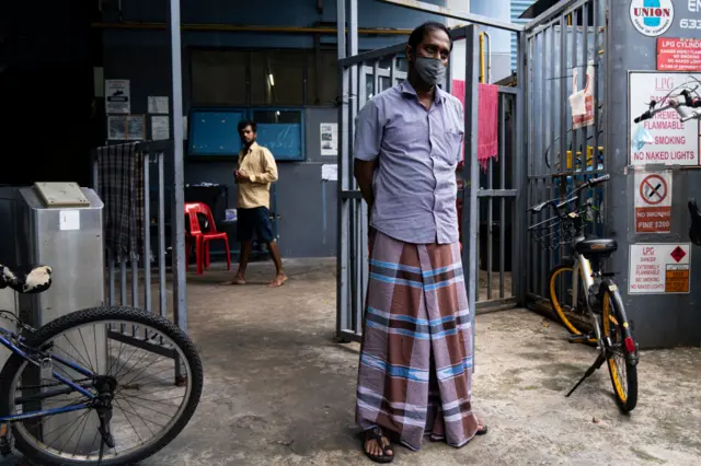 Migrant workers wearing protective face masks can be seen in a factory-converted dormitory for migrant workers on April 20, 2020