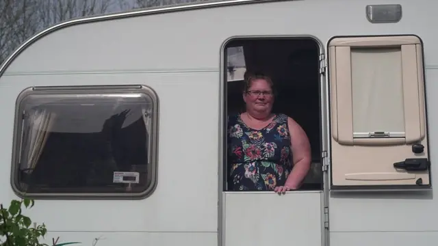 Susan Fraser standing at her caravan