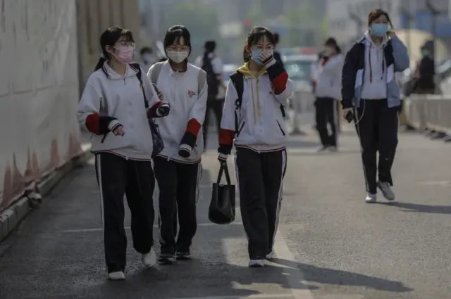 Students wearing face masks leave a high school in Beijing, China, 27 April 2020.