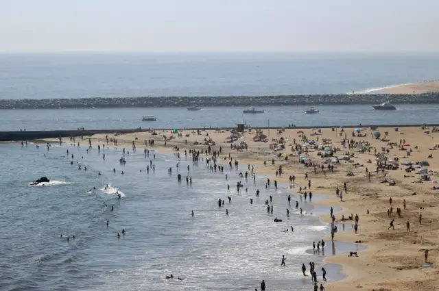 People are seen gathering on the Corona del Mar State Beach on April 25, 2020 in Newport Beach, California