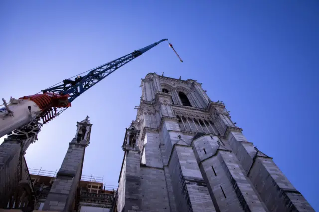 A crane looms over Notre-Dame cathedral in Paris