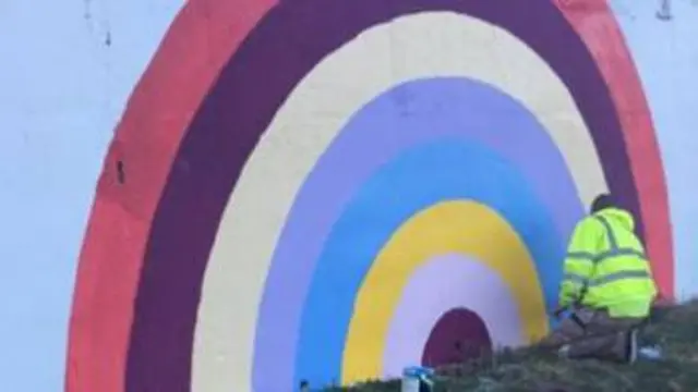 A mural of a rainbow painted in support of frontline NHS workers